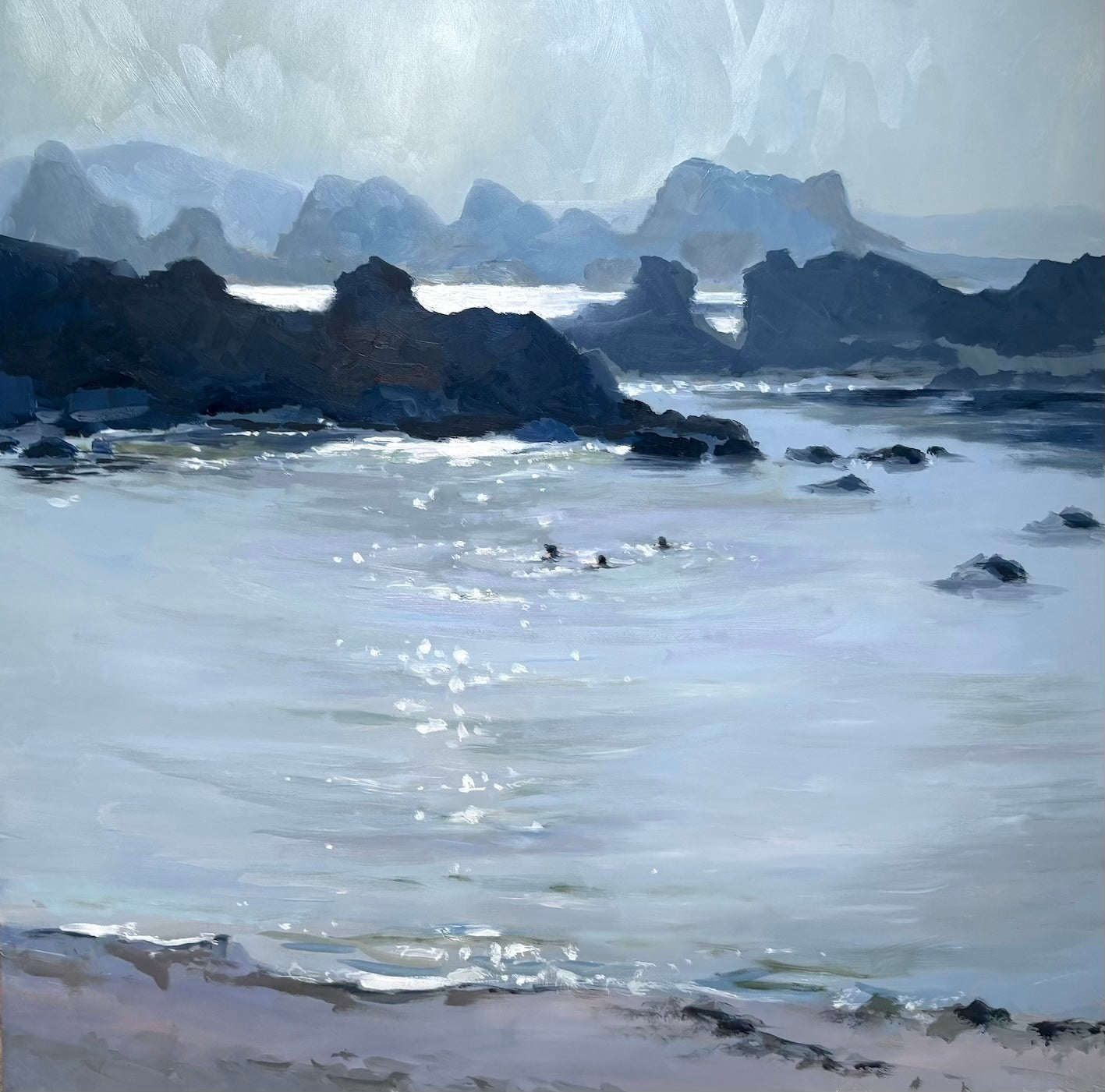 Swimmers in Ballintoy bay in a summer evening with sparkling light